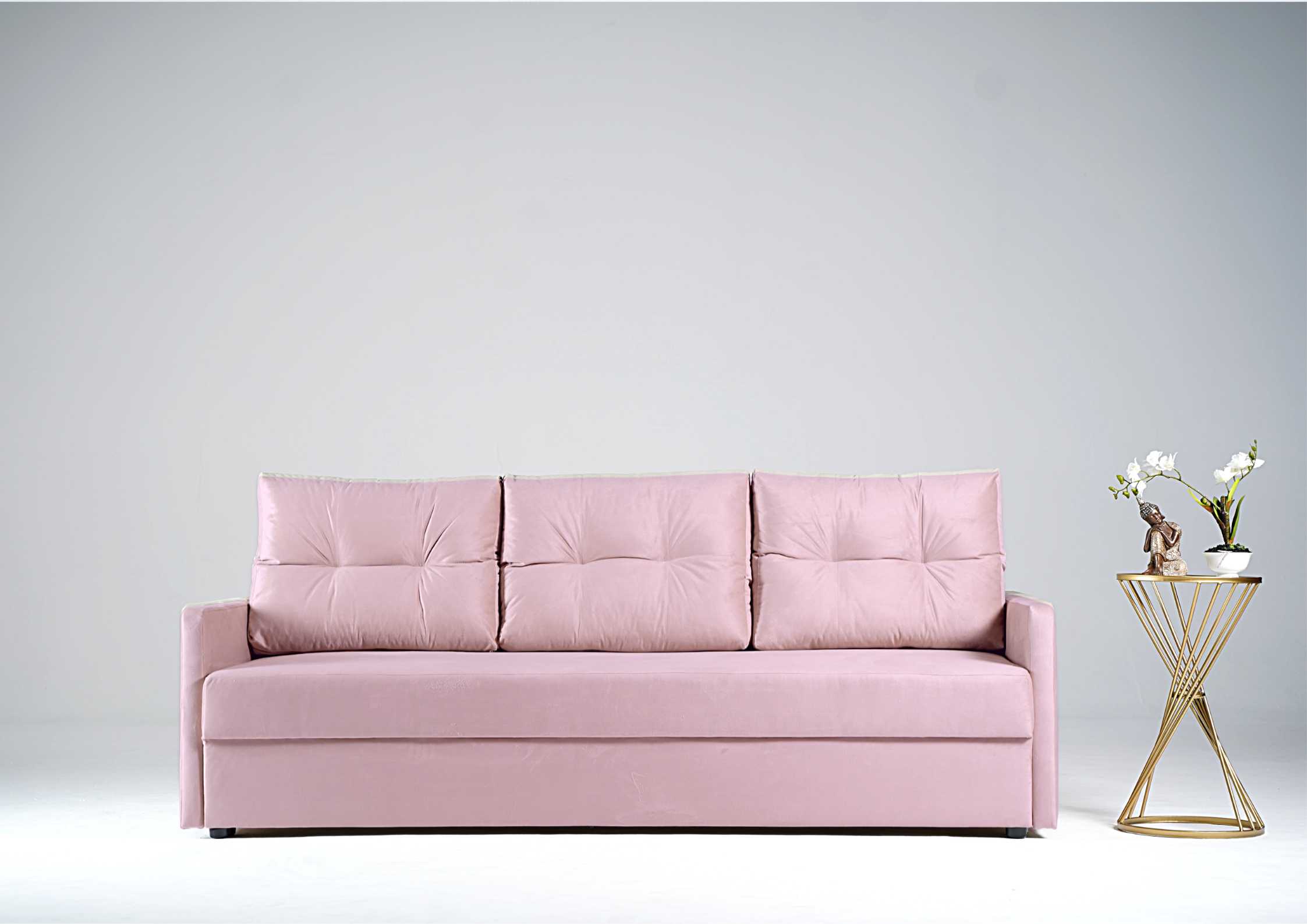 Różowa sofa z pikowanymi poduszkami